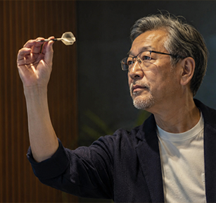 ダーツの的を見つめ、指先でダーツをつまむ大人